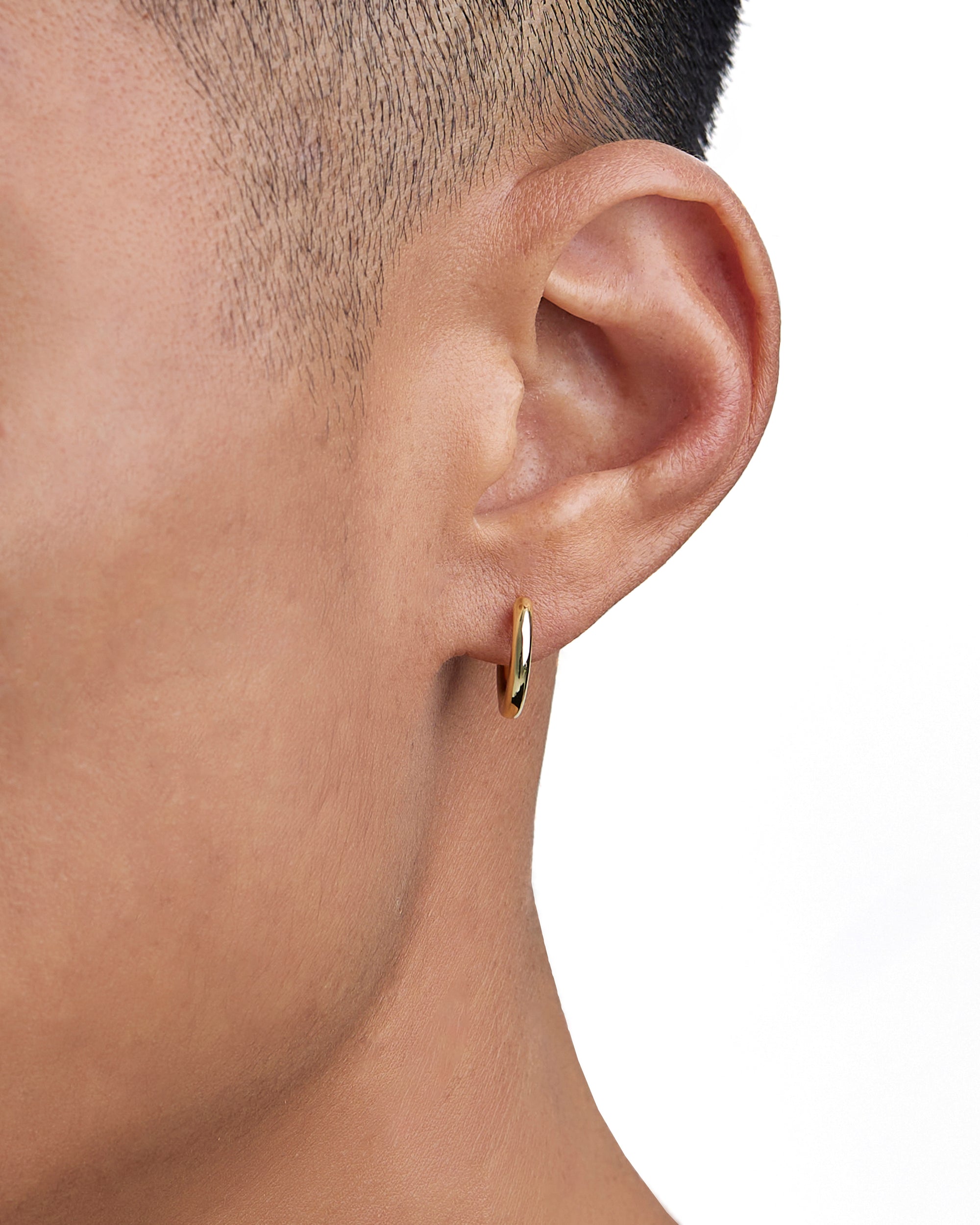 Model wearing 18k gold earrings by Iceman Society